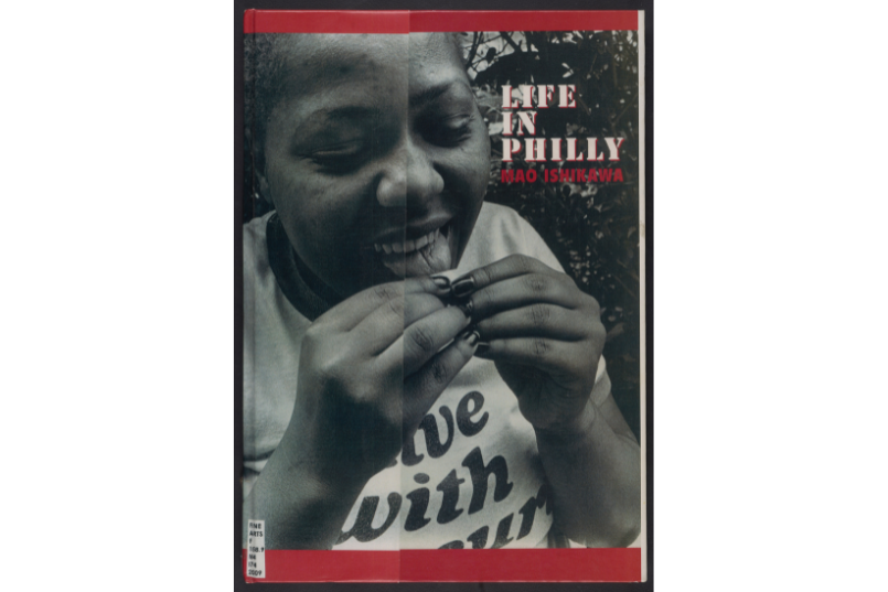 Cover of a book showing an artistic black-and-white photo of a cheerful woman sticking out her tongue. In the corner, the title of the book and author are printed: Life in Philly by Man Ishikawa